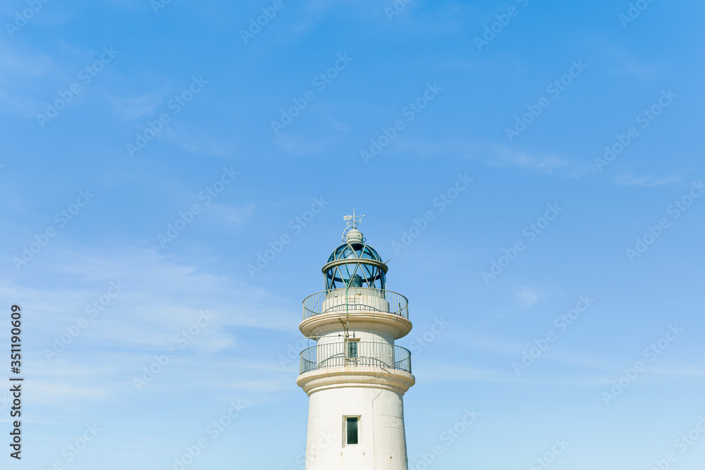 Lighthouse on blue sky in summer time. Concept: vacations, summer.