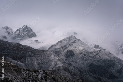 View of snow mountain surrounded by clouds with morning fog © Bob