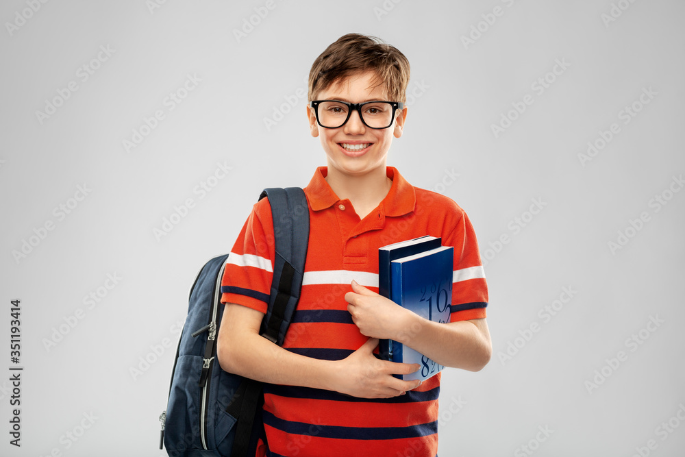 school, education and people concept - smiling student boy in glasses with backpack and books over grey background school, education and people concept - smiling student boy in glasses with backpack and books over grey background