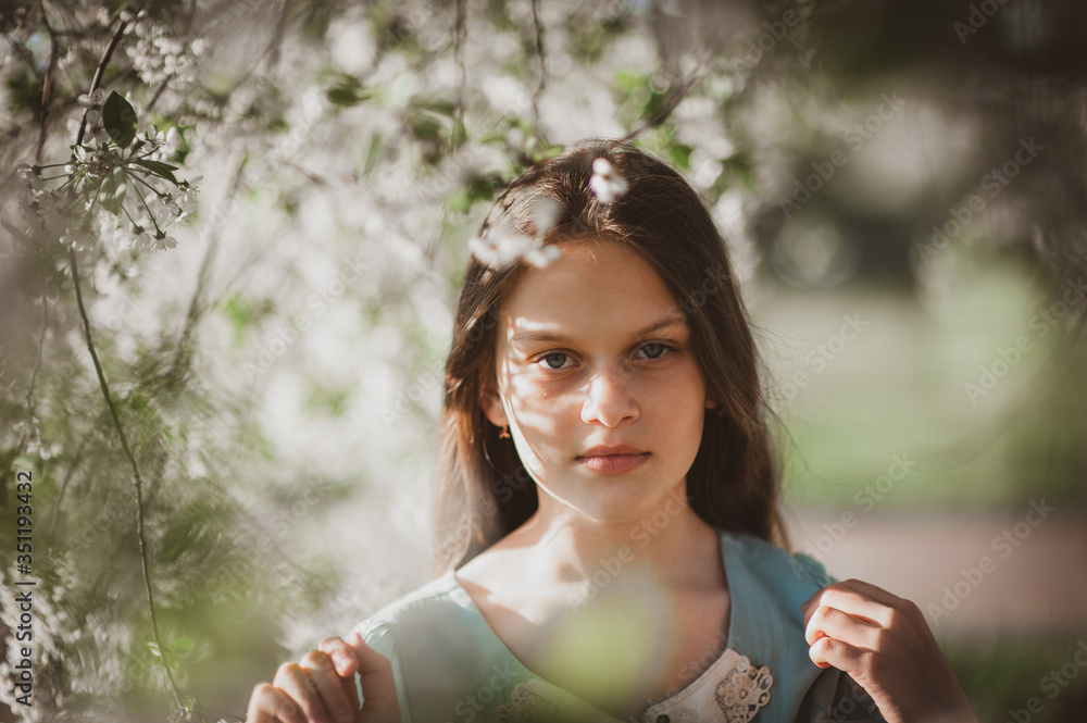 beautiful young girl with long flowing hair in a blooming cherry blossoms garden beautiful young girl with long flowing hair in a blooming cherry blossoms garden