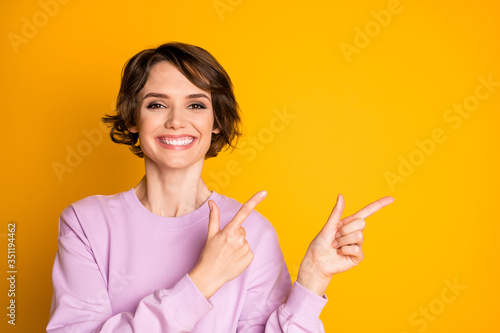 Portrait of positive cheerful girl promoter point index finger copyspace present ads promotion recommend suggest select wear sweater isolated over bright color background