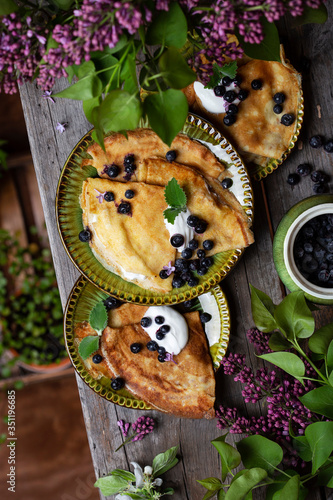 Thin pancakes with blueberries and sour cream