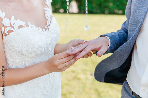 hands of a couple of bride and groom exchanging wedding rings © Олег Блохин