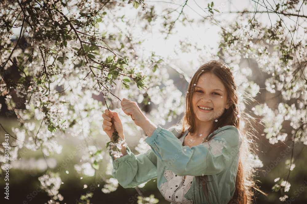 beautiful young girl with long flowing hair in a blooming cherry blossoms garden beautiful young girl with long flowing hair in a blooming cherry blossoms garden