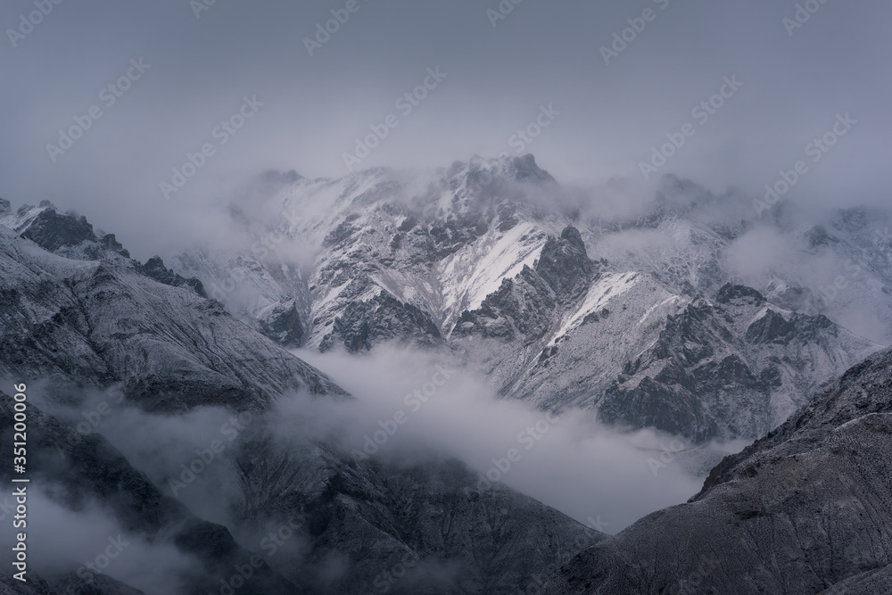 Obraz premium View of snow mountain surrounded by clouds with morning fog