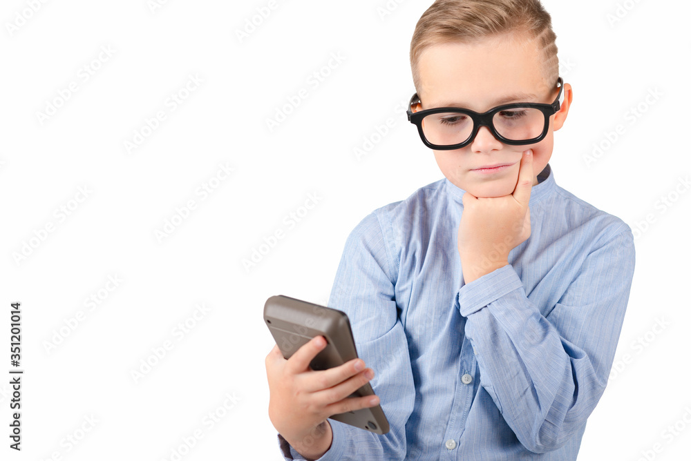 Surprised student holding calculator. Portrait of funny cute teen boy touching his head with hand. Shocked child with calculator looking at camera.White background. Surprised student holding calculator. Portrait of funny cute teen boy touching his head with hand. Shocked child with calculator looking at camera.White background.