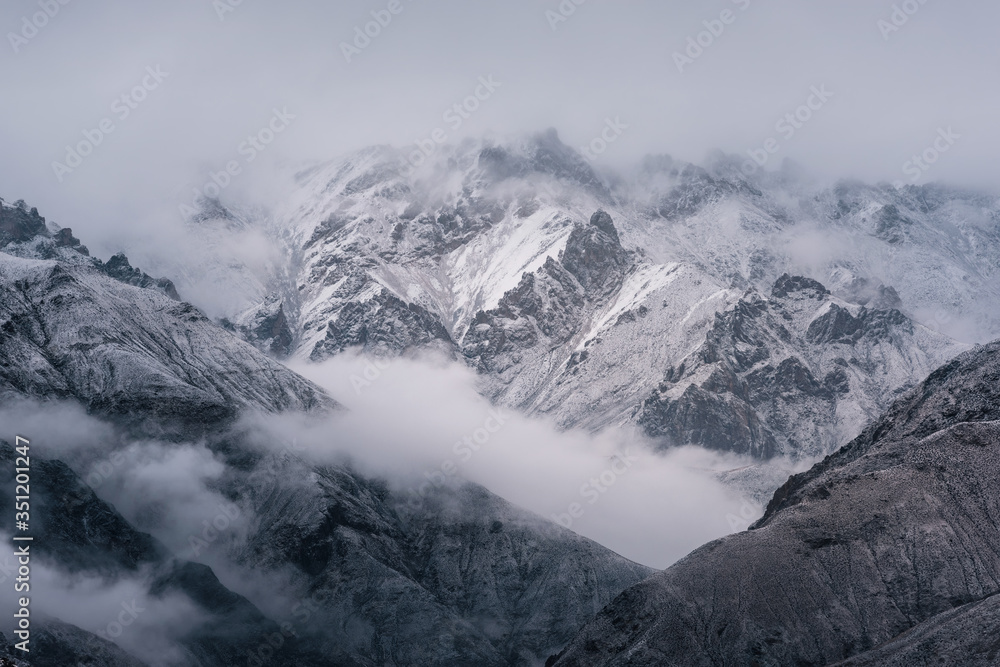 Obraz premium View of snow mountain surrounded by clouds with morning fog