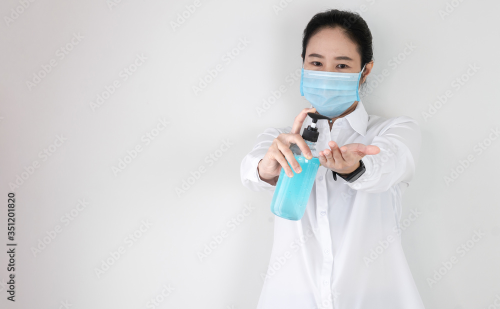 The bottle of alcohol sanitizer cleaner on hand of a nurse or doctor or physician assistant with selective focus