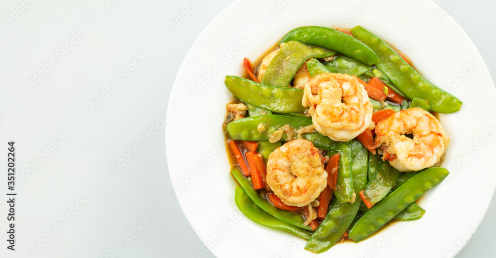 Stir-fried peas, put shrimp in a white plate on a white background. Stir-fried peas, put shrimp in a white plate on a white background.