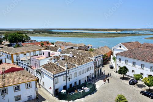 Faro / Algarve, Portugal: View from the observation deck of the Cathedral of Faro, the old city, white buildings with a brown tiled roof, small lakes, sea, in the summer during the daytime.