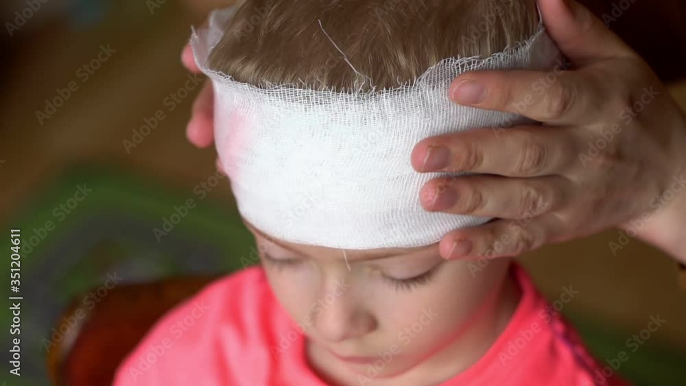 Video Stock mother bandages the child's head. dressing an injured child