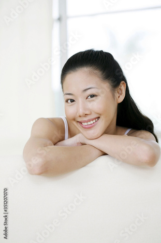 Woman sitting on couch smiling at the camera