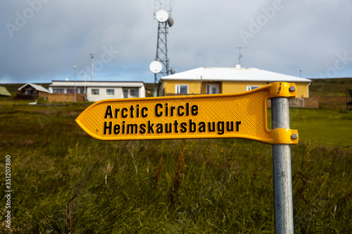 
landscape with the port of the island of grimsey in the north of iceland, off the arctic circle. A yellow sign indicates the direction to follow towards the crossing of the polar circle.
