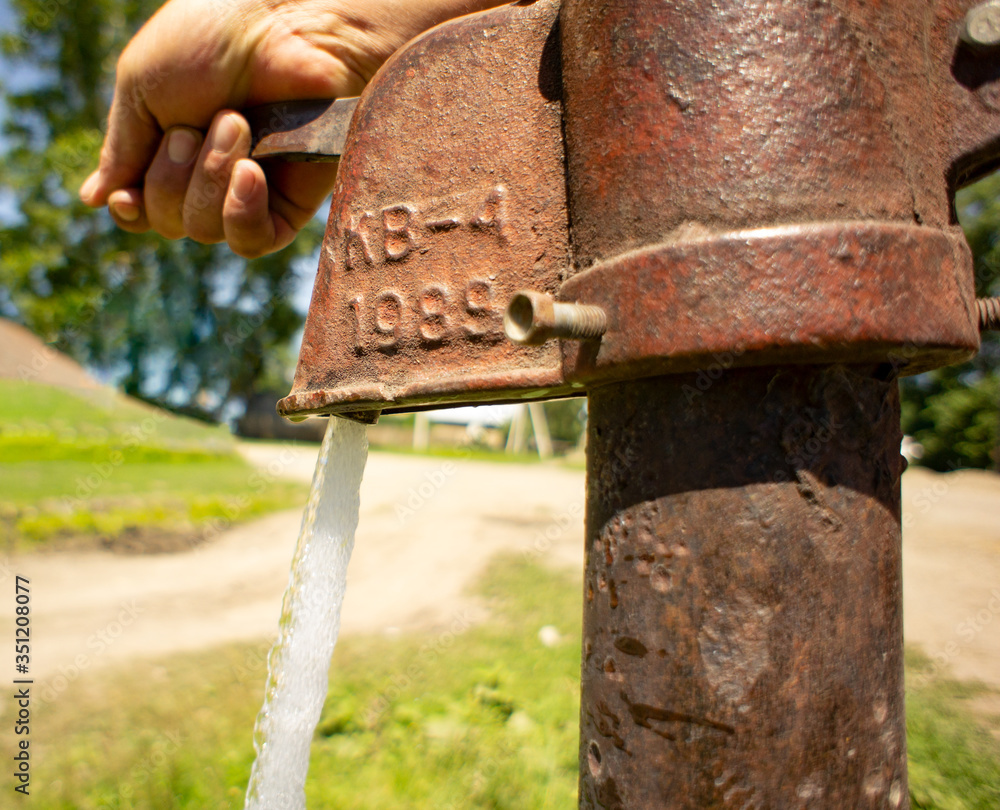 hand opens the water on the old water pump hand opens the water on the old water pump