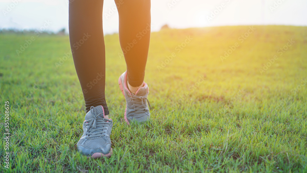 woman legs walking in the park outdoor. female runner running on the road outside .Closeup of fitness getting ready for engage running jogging outdoors woman legs walking in the park outdoor. female runner running on the road outside .Closeup of fitness getting ready for engage running jogging outdoors