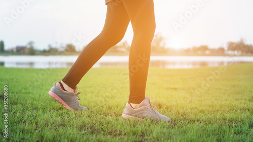 woman legs walking in the park outdoor. female runner running on the road outside .Closeup of fitness getting ready for engage running jogging outdoors