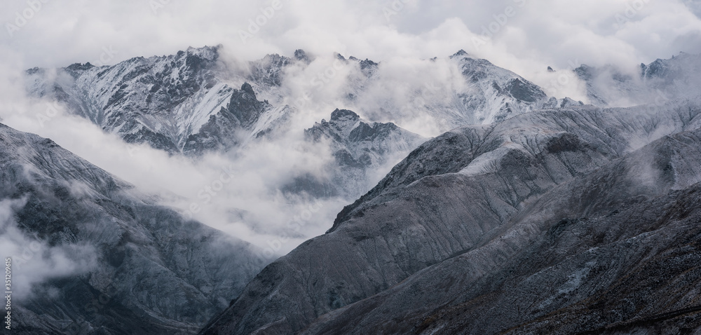 Fototapeta premium View of snow mountain surrounded by clouds with morning fog