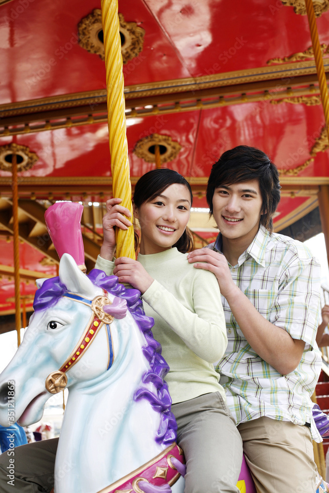 Man and woman riding on carousel Man and woman riding on carousel