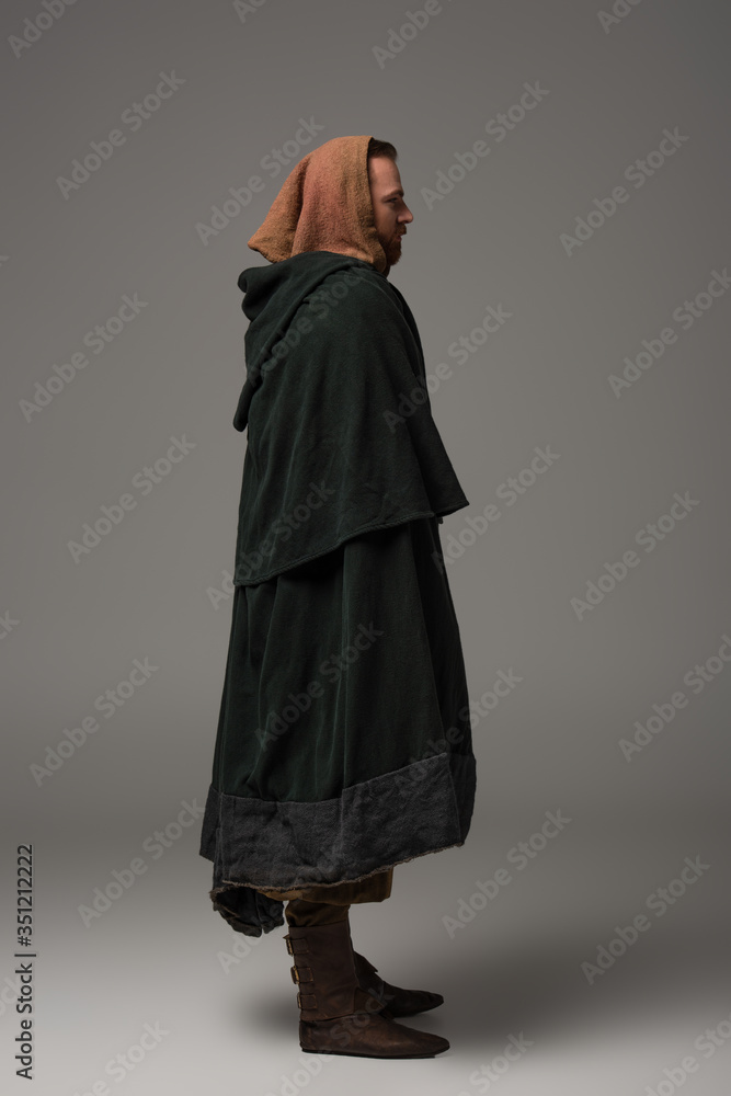 side view of medieval Scottish redhead man in mantel on grey background side view of medieval Scottish redhead man in mantel on grey background