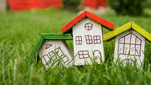 Small houses with color roofs over green grass 