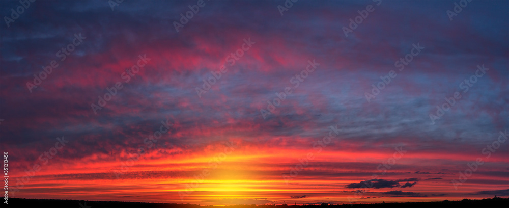 beautiful gentle sunset panorama with large clouds over a small town
