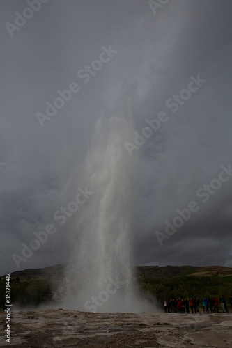 Geyser erupting on Geysir geothermal field in central Iceland. A waterspout flies up to the sky for about 30 meters and immediately drops