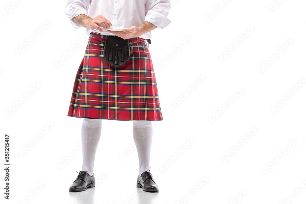 cropped view of Scottish man in red kilt and knee socks with coffee on white background cropped view of Scottish man in red kilt and knee socks with coffee on white background