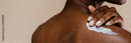 Fotografiet Black woman applying body cream