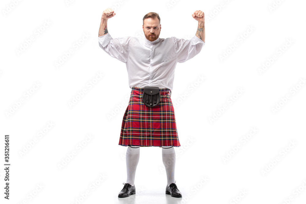 strong Scottish redhead man in red kilt showing fists on white background strong Scottish redhead man in red kilt showing fists on white background