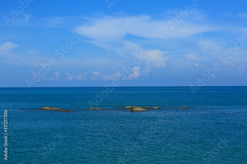 Lanscape view of stones in blue sea and blue sky © cboonfotostock