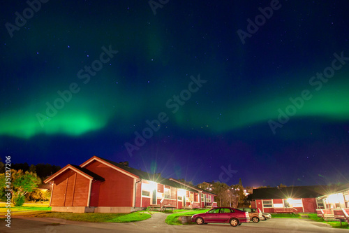 Northern Lights over a house in the countryside and starry sky