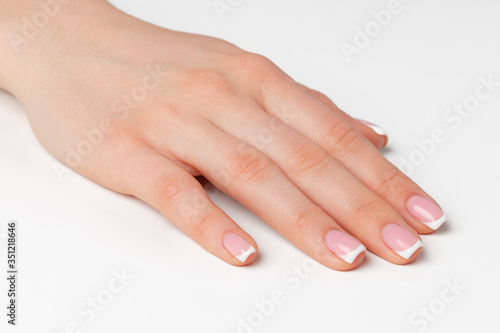 Beautiful female palm with french manicure on white