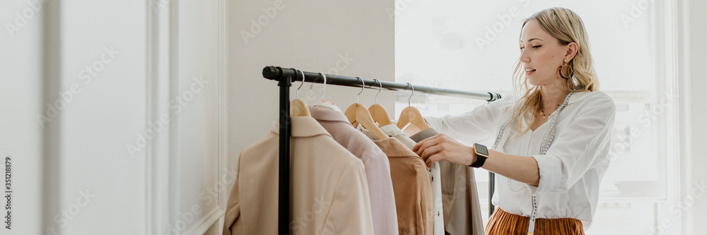 Fashion stylist sorting the clothing rack - obrazy, fototapety, plakaty 