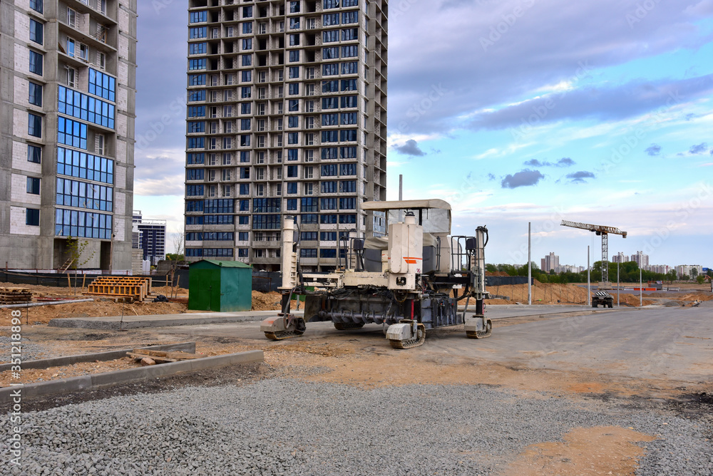 Slipform paver machine on road work at construction site. Highway concrete paving in the new quarter. Repairing concrete roads using new technology Slipform paver machine on road work at construction site. Highway concrete paving in the new quarter. Repairing concrete roads using new technology