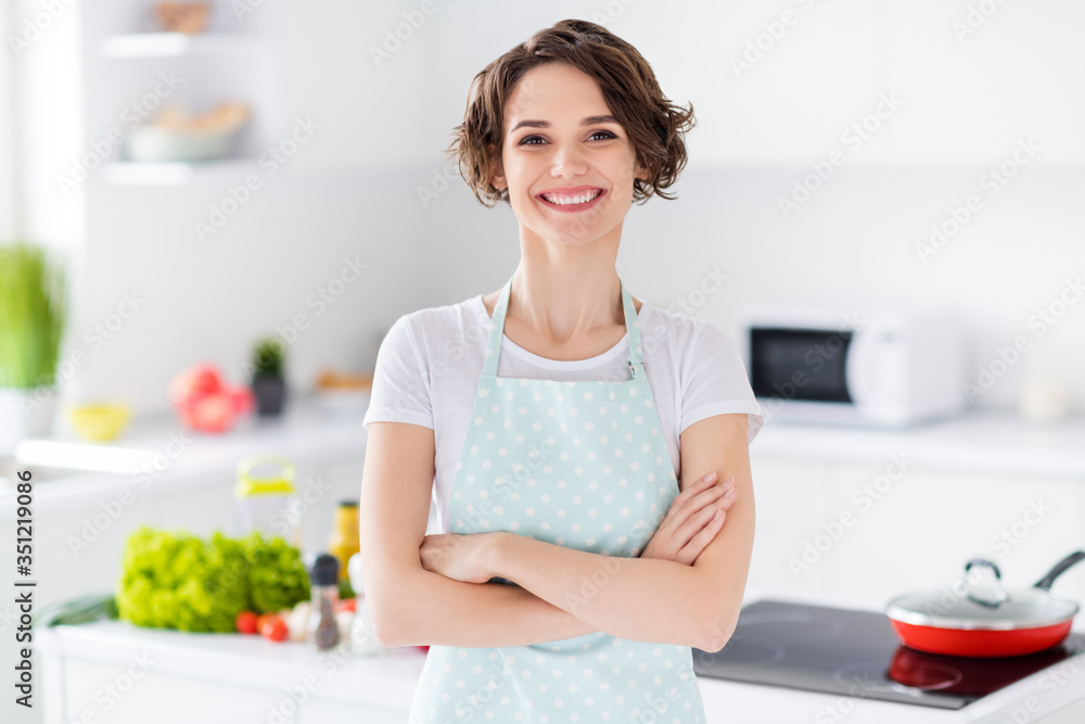 Photo of beautiful bobbed hairdo housewife holding arms crossed enjoy morning cooking tasty dinner family meeting wear apron t-shirt stand modern kitchen indoors Photo of beautiful bobbed hairdo housewife holding arms crossed enjoy morning cooking tasty dinner family meeting wear apron t-shirt stand modern kitchen indoors