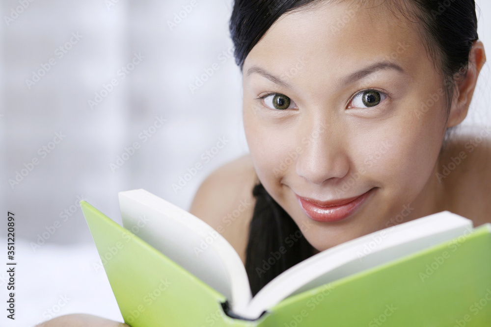 Woman smiling at the camera while holding book Woman smiling at the camera while holding book