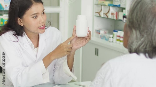 Beautiful asian Pharmacist counseling medication to patient in drug store