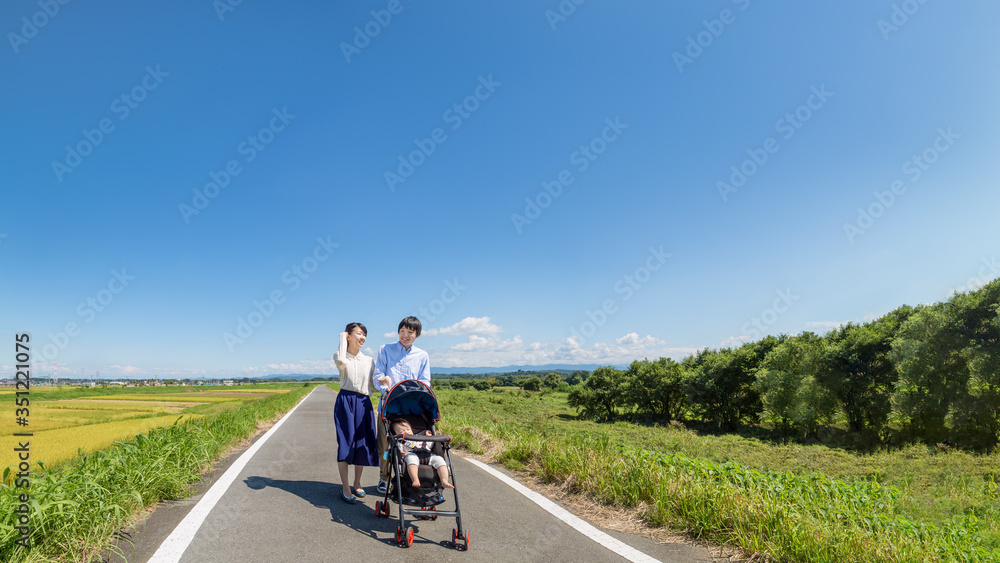 自然の中ベビーカーを押し散歩する若い夫婦(正面) 自然の中ベビーカーを押し散歩する若い夫婦(正面)