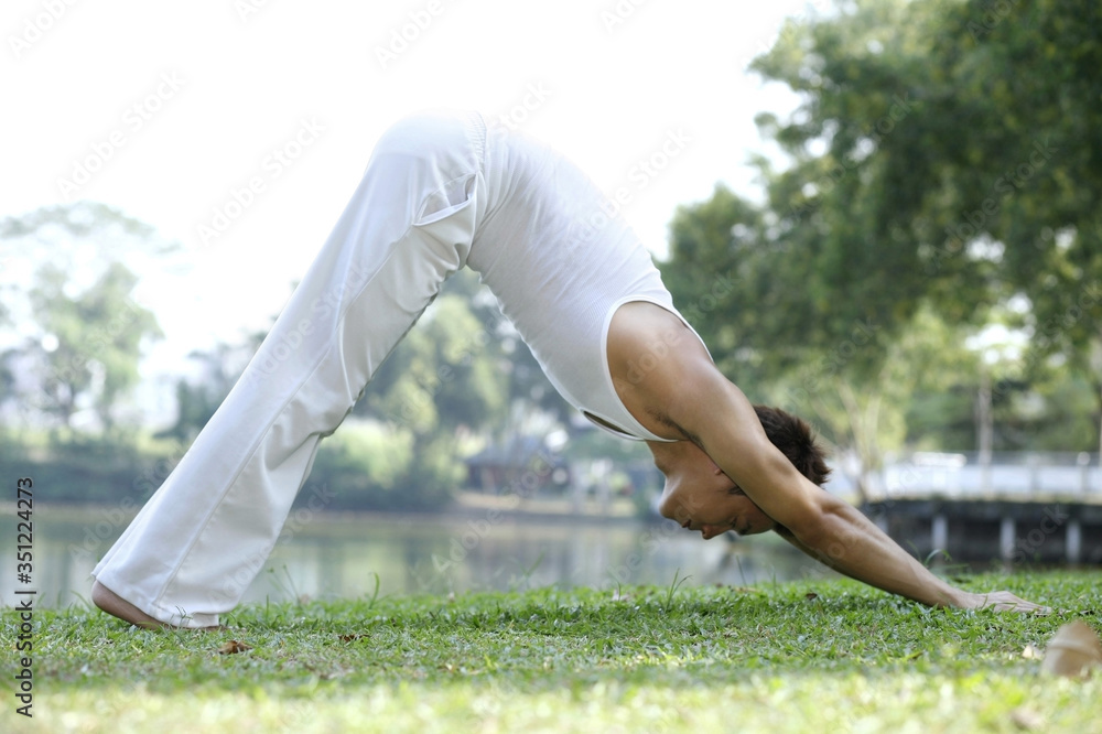 Fototapeta premium Man practising yoga in the park