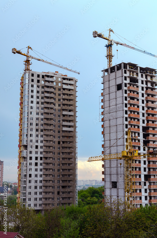 cranes and the construction of new houses in a big city on a warm day, Kiev, Ukraine cranes and the construction of new houses in a big city on a warm day, Kiev, Ukraine