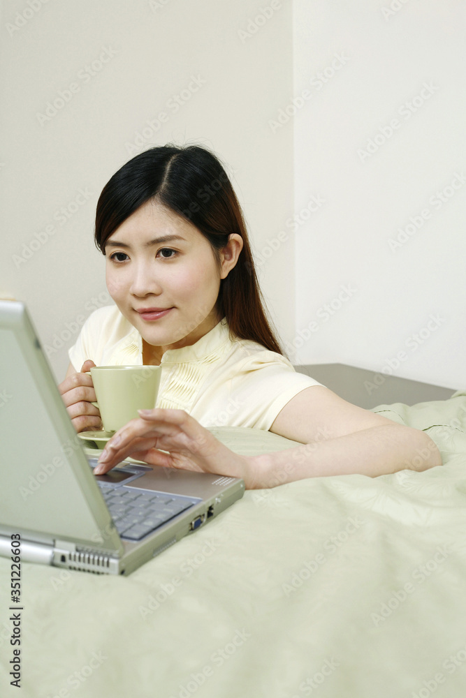 Woman using laptop in the bedroom Woman using laptop in the bedroom
