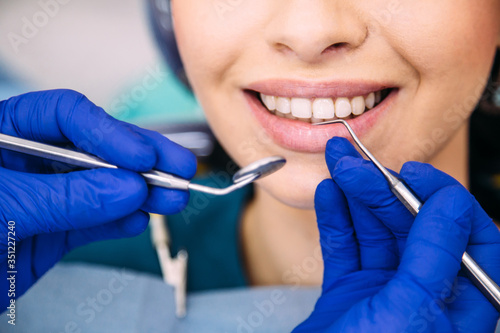 Young attractive brunette girl at the dentist consultation. Checking and dental treatment in a dental clinic.