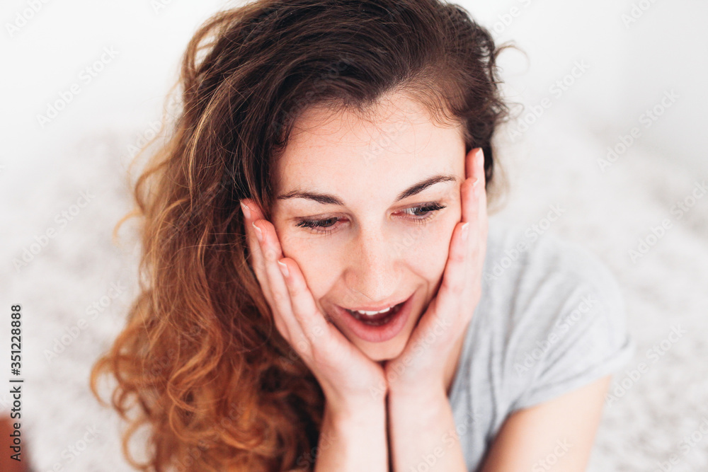 Young woman touching her face with hands, her mouth is open, looking very surprised and shocked Young woman touching her face with hands, her mouth is open, looking very surprised and shocked