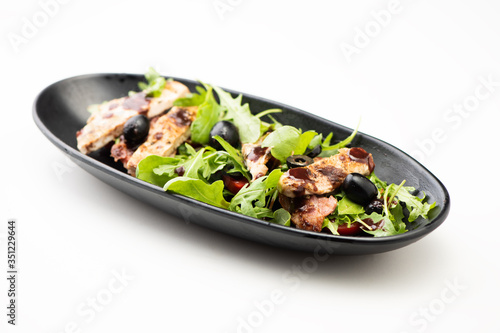 A chicken salad with rucola bacon and tomato