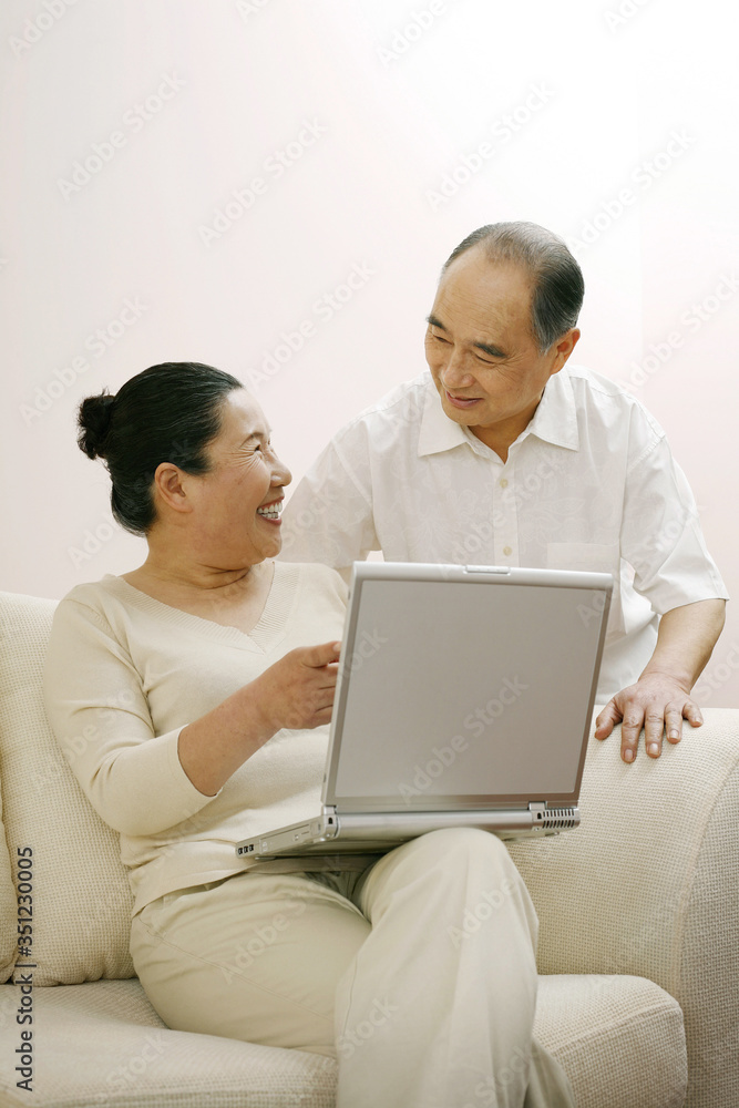 Senior woman talking to senior man while using laptop Senior woman talking to senior man while using laptop