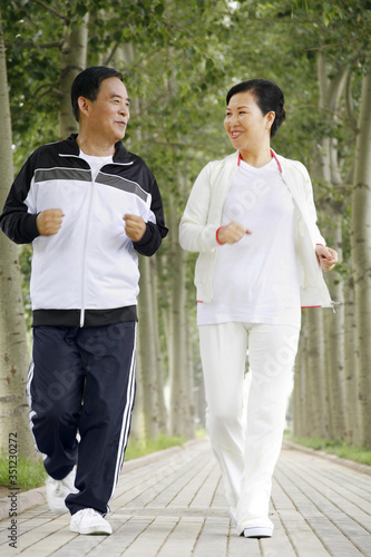 Senior man and woman jogging in the park