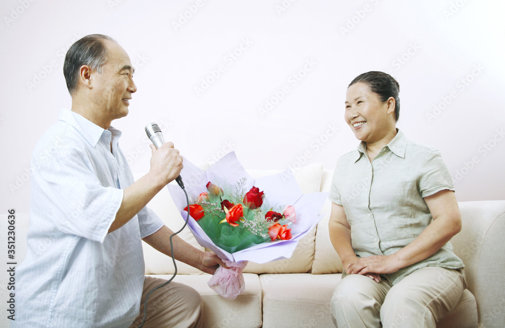 Senior man presenting senior woman with a bouquet of flowers Senior man presenting senior woman with a bouquet of flowers