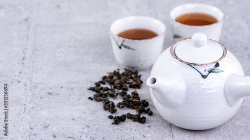 Wallpaper Mural Hot tea in white teapot and cups on a sieve over bright gray cement background, closeup, copy space design concept. Torontodigital.ca
