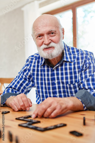 Old man with dementia plays dominoes