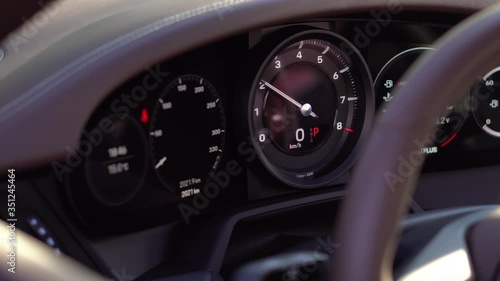 Large speedometer Needle rises up. They started the sports car. Transmission panel. The instrument panel and the technical parameters of the machine. Revs and picks up speed. Resets the speed. Brakes. photo